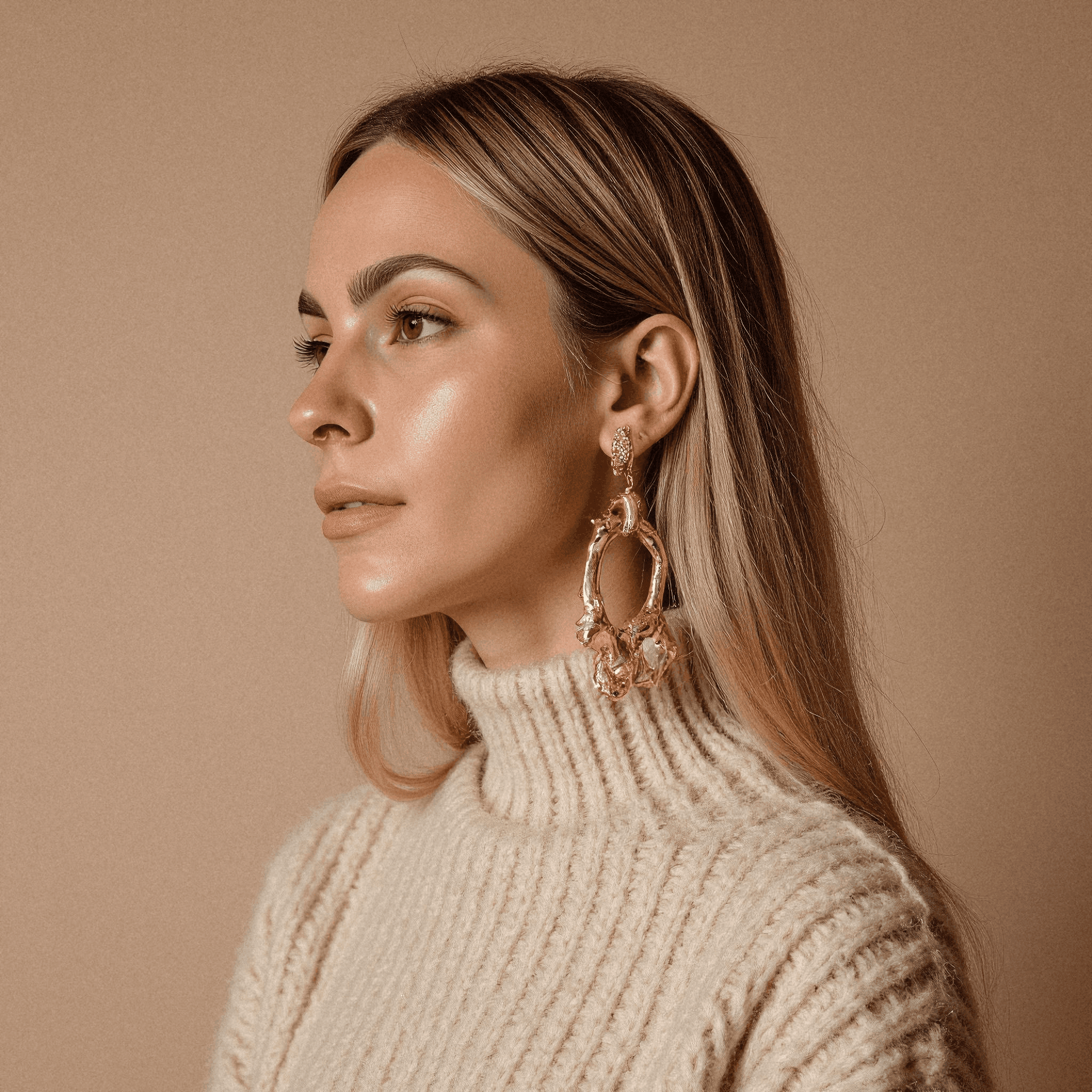 Woman in Beige Sweater with Gold Earrings