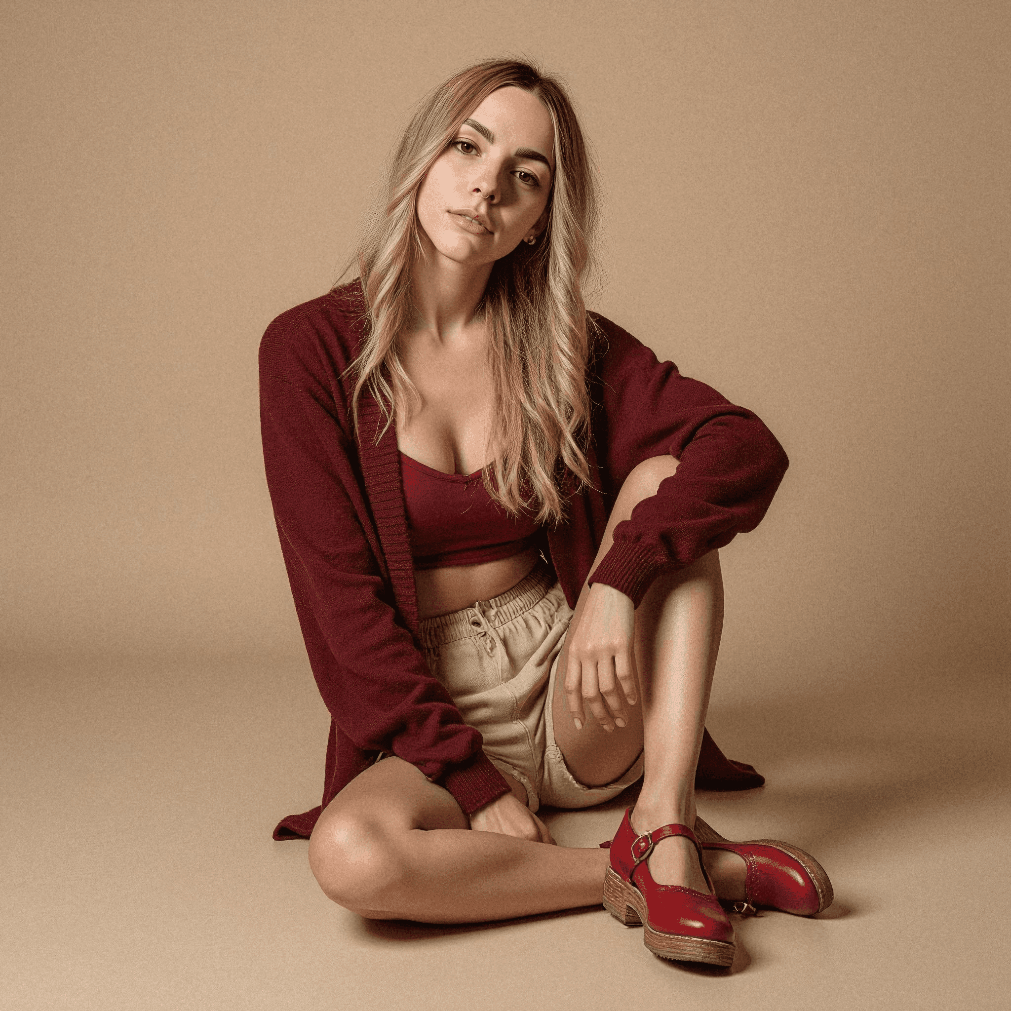 Woman in burgundy cardigan sitting on floor
