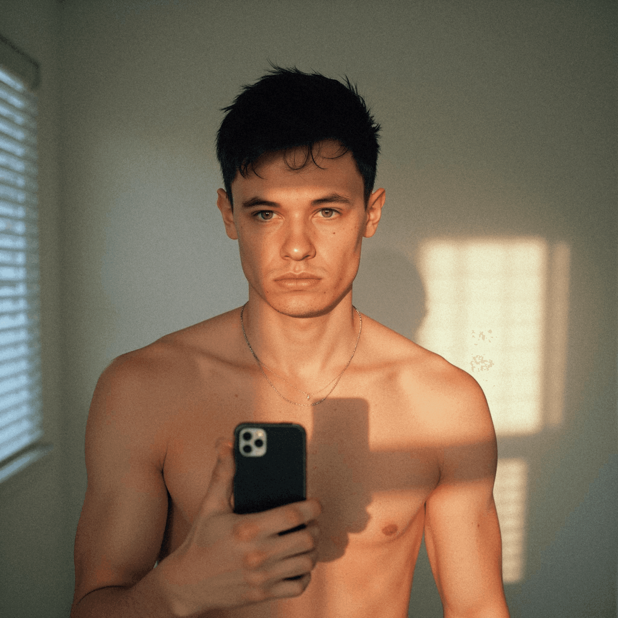 Shirtless man taking a selfie